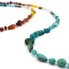 This necklace is made from a gorgeous mix of natural gemstones and Czech glass. Each necklaces is one-of-a-kind and contains carnelian, opalite, red aventurine, ruby jade, turquoise, teal jade and goldstone. Features a sterling silver lobster clasp and chain at the back. This versatile piece can be worn three ways: long, doubled, or as a bracelet. Adjusts from 40 inches to 44 inches long. Amazonite Gemstone Beaded Jewelry, Amazonite Necklace With Polished Beads As Gift, Unique Amazonite Jewelry With Round Beads, Amazonite Gemstone Beaded Necklaces With Round Beads, Amazonite Gemstone Beaded Necklace With Round Beads, Amazonite Gemstone Beaded Necklace, Turquoise Chalcedony Necklace With Natural Stones, Chalcedony Gemstone Necklace With Round Beads, Jade Jewelry With Natural Stones For Meditation