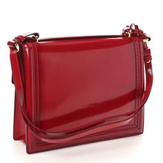 This is an authentic SALVATORE FERRAGAMO Patent Marisol Top Handle Shoulder Bag in Rosso. This chic shoulder bag is finely crafted of red patent calfskin. It features a strap handle, an optional shoulder strap, a frontal flap, and a Ferragamo enamel ring clasp closure. This opens to a black leather interior with a zipper and flat pockets. Studio Bag, Velvet Quilt, Camera Case, Enamel Ring, Purple Bags, Flap Bag, Leather Interior, Salvatore Ferragamo, Top Handle