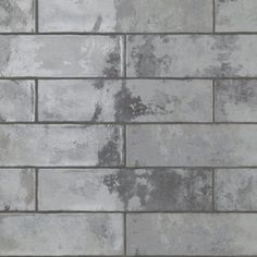 a brick wall that has been painted gray and is being used as a background or backdrop