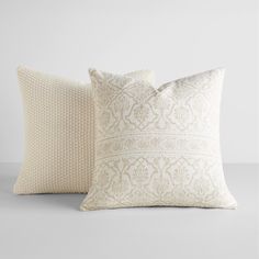 two white pillows sitting next to each other