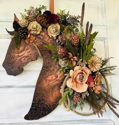 a horse head decorated with flowers and leaves on the front door to a house or business