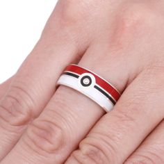 Show your loved one that you choose them; with this pokeball ring in a sterling silver band! White, red, and black enamel come together around a sparkling Moissanite stone to make this pokemon ring something truly special. RING LAYOUTRing Width: 9 mmRing Sleeve: Sterling SilverRing Profile: FlatRing Finish: Polished 1 mm Sterling Silver2.5 mm White Enamel0.5 mm Sterling Silver1 mm Black Enamel0.5 mm Sterling Silver2.5 mm Red Enamel1 mm Sterling Silver Stone: Moissanite (Qty: 1)Shape/Size: Round, Pokemon Ring, Meteorite Wedding Rings, Nerd Wedding, Titanium Wedding Band, Special Ring, Band Jewelry, Ring Fit, Mens Wedding Rings, Sterling Silver Bands