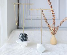 two vases filled with flowers on top of a white table