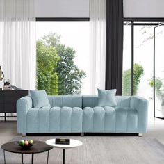 a living room with a blue couch and coffee table in front of a large window