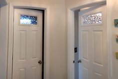 two white doors in a room with glass panels on the top and bottom door frames