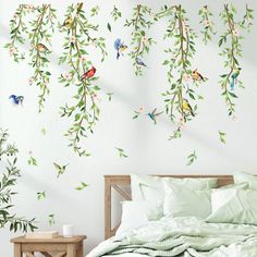 a bed sitting under a wall with birds on it