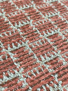 an orange and grey rug with white lines on the top is shown in close up