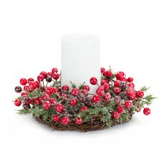 a candle is surrounded by red berries and pine cones