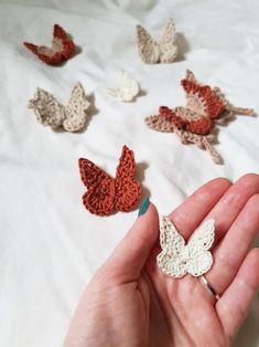 someone is holding some crocheted butterflies in their hand