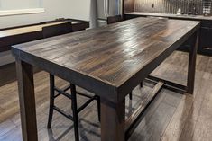 a wooden table sitting in the middle of a kitchen