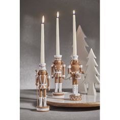 three wooden nutcrackers with candles in front of them