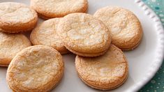 a white plate topped with sugar cookies on top of a blue and white table cloth