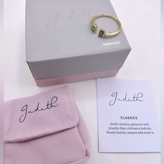 a ring sits on top of a pink box next to a note with the name julia