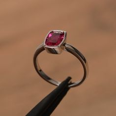 It is a lab ruby ring. The main stone is 6 mm*8  mm cushion cut.weight about 1.82 carats.The basic metal is sterling silver and plated with rhodium.To change the metal to a solid gold (white/rose) or platinum is also available, please ask for a quotation if you want.You can also go to my shop Home for more elegant rings: https://www.etsy.com/shop/godjewelry?ref=hdr_shop_menu Ruby is July birthstone More ruby rings:https://www.etsy.com/shop/godjewelry?ref=seller-platform-mcnav&section_id=20709238 Cushion Cut Ruby Jewelry Gift, Cushion Cut Ruby Jewelry As Gift, Cushion Cut Ruby Jewelry For Gift, Modern Cushion Cut Jewelry For Gift, Modern Jewelry For Gift Occasions, Square Cut Ruby Jewelry Fine Jewelry, Anniversary Lab-created Ruby Cushion Cut Jewelry, Asscher Cut Ruby Fine Jewelry, Elegant Silver Ruby Ring With Cushion Cut