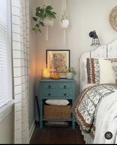 a bedroom with a bed, nightstand and plants on the headboard next to it