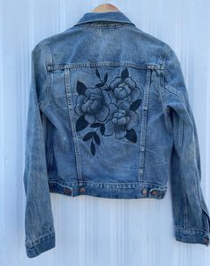 a denim jacket with flowers painted on it