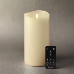 a lit candle next to a remote control