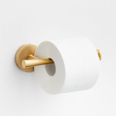 a roll of toilet paper is hanging on the wall next to a gold - plated handle