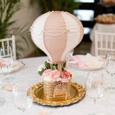 a hot air balloon centerpiece sitting on top of a gold plated platter