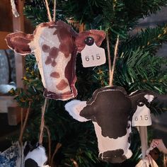 ornaments made to look like cows hanging from a christmas tree with price tags on them