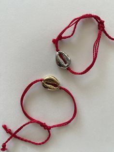 handmade summer themed lucky red string bracelet with gold/silver cowrie shell charm and adjustable size. Handmade Cowrie Shell Friendship Bracelets As Gift, Handmade Red Braided Bracelets For Beach, Handmade Red Braided Bracelet For Beach, Red Friendship Bracelets For Beach, Bohemian Red Friendship Bracelets For The Beach, Resizable Red Jewelry For Beach, Red Adjustable Friendship Bracelets For Beach, Red Adjustable Cord Friendship Bracelets For Beach, Adjustable Red Bracelets For Beach