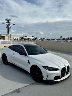 a white sports car parked on top of a parking lot