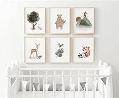 a white crib with four framed pictures on the wall and a baby's bed next to it