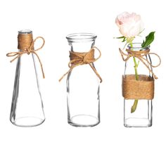 three glass vases tied with twine and one pink rose in the middle, on a white background