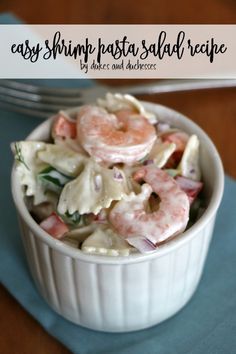 shrimp pasta salad recipe in a white bowl on a blue place mat with silverware