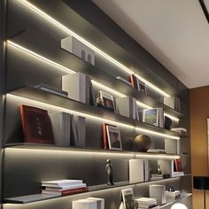 the shelves are filled with books and other items in this modern home office area that is lit up by recessed lighting