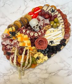 a platter filled with different types of cheeses and meats on a marble counter top