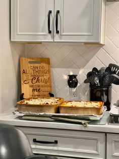 two pizzas sitting on top of a counter in a kitchen