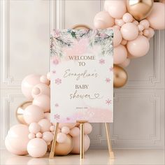 a welcome sign surrounded by balloons and streamers in front of a white wall with pink flowers