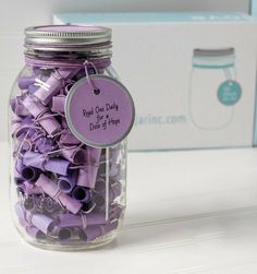 a jar filled with purple paper clips next to a box of blue and white tags