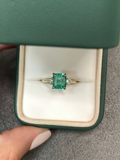 A classic Colombian emerald and diamond engagement, statement, or right-hand ring. Dexterously crafted in gleaming 14K gold this ring features a 1.81-carat natural Colombian emerald-emerald cut from the famous Chivor mines. Set in a secure prong setting, this extraordinary emerald has a bright green color and glow. This emerald has very good eye clarity with natural Jardins that occur in all earth-mined emeralds. Pear diamonds weighing 0.30pts total accent on either side of the emerald. Setting: Crazy Rich Asians Wedding Ring, Emerald Cut Rings Gold, Small Green Engagement Ring, Colombian Emerald Engagement Ring, Understated Engagement Rings, Crazy Rich Asians Ring, Wedding Manifestation, Three Stone Engagement Rings Emerald, Emerald Ring Engagement