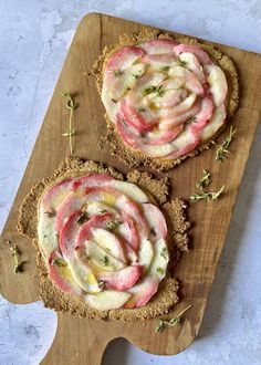 two food items on a cutting board with some sprigs and herbs around them