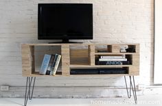 an entertainment center made out of wood and metal legs