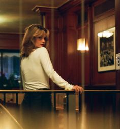 a woman leaning on a railing in an office building