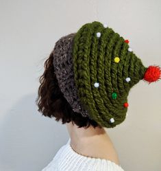 a woman wearing a crocheted hat with pom - poms on it