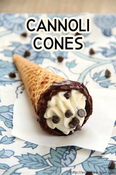 an ice cream cone with chocolate chips on it sitting on top of a table cloth