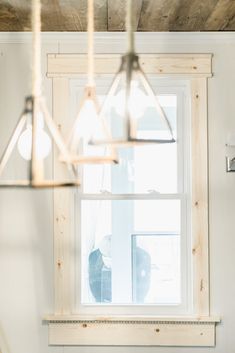 a kitchen window with lights hanging over it