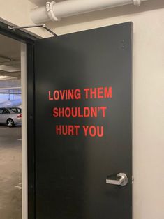 a black door with red writing on it that says loving them shouldn't hurt you