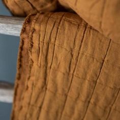 a close up view of a bed with an orange comforter