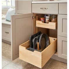 an open drawer in a kitchen filled with pots and pans