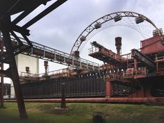 a large metal structure sitting on top of a lush green field