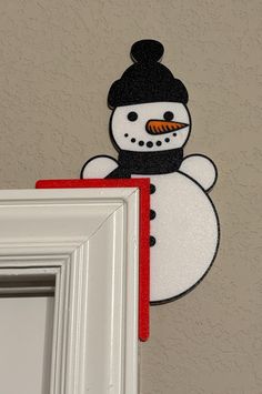 a snowman is hanging on the wall next to a door