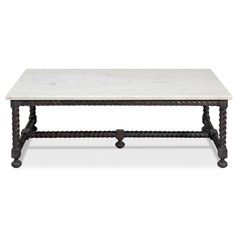 a marble top coffee table with iron legs and an intricate design on the base,