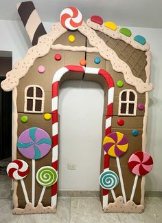 a gingerbread house made out of cardboard with candy and candies on the front