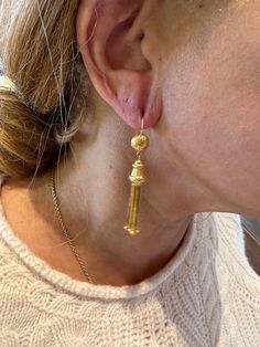 The Etruscan revival period of the late 1800s was inspired by the findings of archaeological digs in and around Rome. The Etruscans inhabited the area before the Romans did! The ancient jewelry being found was marked by gold granulation, filigree, and classical cultural themes. These Etruscan revival earrings were likely made at the tail of the 19th century and have a group of gold tassels suspended from a floral themed gold finial. The tassel and finial are suspended from a half sphere that's e Antique Gold Earrings With Historical Design, Historical Yellow Gold Drop Earrings, Antique 14k Gold Dangle Jewelry, Yellow Gold Historical Drop Earrings, Traditional Yellow Gold Earrings With Historical Design, Yellow Gold Drop Earrings With Historical Design, Elegant Yellow Gold Earrings With Historical Design, Antique Jewelry With Historical Design Drop Earrings, Antique Jewelry Drop Earrings With Historical Design