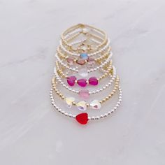 All of our bracelets are handmade in Hoboken, NJ, a little town which is near and dear to our hearts. This beautiful Swarovski heart bracelet is completely customizable - chose a single crystal heart or three. Also choose from 8 colors: red, fuchsia, rose, dusty lilac, mermaid, unicorn, clear, and silk. One inch of extra chain lets you adjust the bracelet to your preference. All items are hand-made in the USA in a smoke-free studio, and most importantly, they're made with OurWholeHeart❤︎ ------- Adjustable Crystal Bracelet With Heart Beads For Gift, Adjustable Heart Beads Crystal Bracelet Gift, Silver Beaded Crystal Bracelet For Valentine's Day, Valentine's Day Silver Beaded Crystal Bracelet, Adjustable Dainty Beaded Bracelets For Valentine's Day, Adjustable Heart-shaped Crystal Bracelet Gift, Dainty Adjustable Beaded Bracelets For Valentine's Day, Dainty Handmade Heart-shaped Beaded Bracelets, Beaded Jewelry For Birthday On Valentine's Day